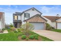 Charming two-story home features a brick facade, attached garage, and landscaped front yard at 6459 Titania Dr, Indianapolis, IN 46236