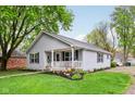 Well-manicured front lawn with a single-story home featuring a charming covered porch and light gray siding at 709 S Meridian St, Lebanon, IN 46052