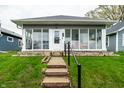 Gray single story home with a glass enclosed front porch, short walk and well-maintained lawn at 71 S 9Th Ave, Beech Grove, IN 46107