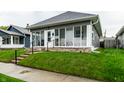A quaint one-story home featuring a glass-enclosed front porch with steps to the landscaped front yard at 71 S 9Th Ave, Beech Grove, IN 46107