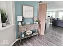 Inviting foyer with a stylish console table, attractive decor, and views of the open-concept living area at 7141 Lillian Pl, Cumberland, IN 46229