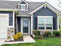 Close-up of the front entrance featuring stylish blue siding, decorative stonework and an inviting covered porch at 7141 Lillian Pl, Cumberland, IN 46229