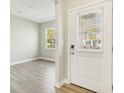 Bright entryway with wood-look floors, leading to a spacious area with natural light from the window at 7277 Governors Row, Avon, IN 46123