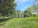 Charming yellow two-story home featuring a covered front porch and manicured lawn at 7561 N Hall School Rd, Monrovia, IN 46157