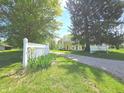 Charming yellow two-story home with picket fence and gravel driveway at 7561 N Hall School Rd, Monrovia, IN 46157