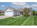 Attractive home with a neatly kept lawn, flowering tree, and an attached two-car garage at 7652 Wood Stream Dr, Indianapolis, IN 46239