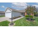 Inviting home exterior with lush green lawn and a blooming tree in the front yard at 7652 Wood Stream Dr, Indianapolis, IN 46239