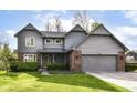 Charming home with an attached two-car garage, gray siding, brick accents and well-maintained lawn and landscaping at 8242 Windhaven Cir, Indianapolis, IN 46236