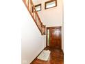 Inviting foyer features hardwood floors, staircase with wooden railings, and a solid wood front door with glass panes at 8242 Windhaven Cir, Indianapolis, IN 46236