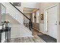 Inviting foyer with a staircase, light wood floors, and decor creating a welcoming entrance at 8277 Plumwood Ln, Indianapolis, IN 46256
