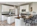 Modern kitchen with white cabinets, dark granite countertops and seating perfect for entertaining at 8277 Plumwood Ln, Indianapolis, IN 46256