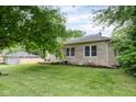 Exterior of the home with a grassy lawn, stone accents, and a detached garage in the background at 840 N Indiana St, Mooresville, IN 46158