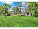 Charming stone home featuring a well-maintained lawn and mature shade trees at 840 N Indiana St, Mooresville, IN 46158