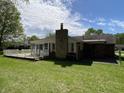 Expansive backyard featuring a stone chimney, well maintained lawn and a wooden deck at 89 Judy Dr, Martinsville, IN 46151