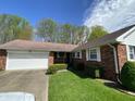 Charming single story brick home with manicured lawn, two car garage and concrete driveway at 89 Judy Dr, Martinsville, IN 46151