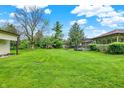 Spacious backyard with lush green grass, mature trees, and a swing set for outdoor enjoyment at 8906 N County Road 1050 E, Brownsburg, IN 46112