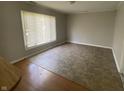 Spacious living room with a large window and a mix of vinyl and hardwood flooring at 9048 E 36Th St, Indianapolis, IN 46235