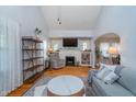 Bright living room featuring vaulted ceilings, a cozy fireplace, hardwood floors, and stylish decor at 914 Kessler Blvd E Dr, Indianapolis, IN 46220