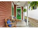 Inviting front porch with outdoor seating, ferns, and a striped rug create a welcoming entrance at 946 Stillwell St, Indianapolis, IN 46202