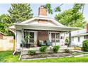 Charming home featuring a cozy front porch with decorative ironwork and well-maintained landscaping at 1030 N Butler Ave, Indianapolis, IN 46219