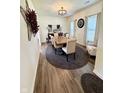 Elegant dining room featuring a modern chandelier, wood-look flooring, and bright natural light at 1119 E Main Cross St, Edinburgh, IN 46124