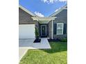 Charming front entrance featuring a stylish black door with wreath, black shutters, and fresh landscaping at 1119 E Main Cross St, Edinburgh, IN 46124