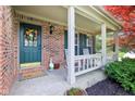 Inviting front porch with white rocking chairs and a welcoming wreath, adding to the home's curb appeal and charm at 11205 Echo Ridge Ln, Indianapolis, IN 46236