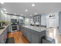 Spacious kitchen with gray cabinetry, large island, stainless steel appliances, and hardwood floors at 11469 Burkwood Dr, Carmel, IN 46033