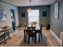 Elegant dining room with a wooden table set, modern lighting, and stylish wall art at 11651 Congressional Ln, Indianapolis, IN 46235