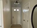 Bright hallway featuring wood-look flooring, white trim, and a modern light fixture that welcomes you inside at 1316 Long Shore Dr, Indianapolis, IN 46217