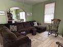Cozy living room featuring a large sectional sofa, vintage rocking chair, and a view into the dining area at 1337 N Olney St, Indianapolis, IN 46201