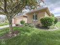Well-maintained brick home featuring a lush green lawn and mature trees at 1395 Heron Ridge Blvd, Greenwood, IN 46143
