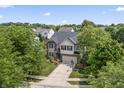 Two-story home featuring brick and siding, a well-maintained lawn, mature trees, and a driveway with a basketball hoop at 15936 Symphony Blvd, Noblesville, IN 46060