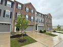 A row of three-story townhouses featuring brick and gray siding with well-maintained landscaping at 17364 Graley Pl, Westfield, IN 46074