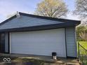 Attached garage with a large white door, providing ample space for parking and storage at 1817 Sparrow Ave, Indianapolis, IN 46227