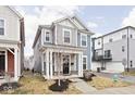 Attractive two-story home featuring a welcoming front porch, complemented by stylish blue and gray exterior paint at 214 Handley St, Indianapolis, IN 46222