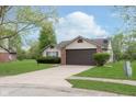 Traditional single-story home with a two-car garage and a neat front yard, creating a welcoming view at 308 Creekstone Ct, Indianapolis, IN 46239