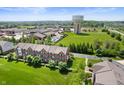 Stunning aerial view of a brick townhouse complex with manicured lawns and a water tower at 3546 Golden Gate N Dr, Carmel, IN 46074