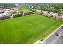 Expansive aerial view showcasing a green field near a brick townhouse development at 3546 Golden Gate N Dr, Carmel, IN 46074