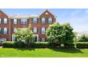 Attractive brick townhouse with green shutters and lush landscaping on a sunny day at 3546 Golden Gate N Dr, Carmel, IN 46074