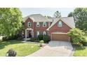 Attractive brick home with a well-manicured lawn, mature trees, attached garage, and classic design at 3601 Lakeshore Ct, Greenwood, IN 46143