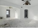 Spacious living room awaiting renovation, featuring archways, vintage ceiling fans, and ample natural light at 3706 Baltimore Ave, Indianapolis, IN 46218