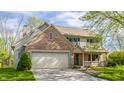 Charming two-story home featuring a brick facade, attached garage, and lush green lawn at 3808 Brigade Cir, Carmel, IN 46032