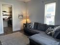 Comfortable living room featuring a gray sectional sofa and view into the kitchen at 40 N Park Ave, Martinsville, IN 46151