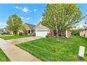 A beautiful home with a well-manicured lawn and lush green trees at 4809 Ozark Ln, Indianapolis, IN 46239
