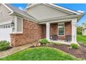 Inviting covered front porch with brick accents and a cozy seating area at 4809 Ozark Ln, Indianapolis, IN 46239