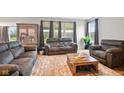 Comfortable living room with plush seating, large windows, neutral tones, and views of a landscaped exterior at 4844 Morenci Ct, New Palestine, IN 46163