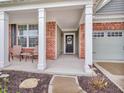 Inviting covered porch with brick accents, white columns, and comfortable seating area at 4857 Silverbell Dr, Plainfield, IN 46168