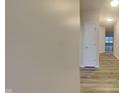 Bright hallway featuring wood-look flooring, white doors, and recessed lighting at 6118 Aspen Meadow Dr, Indianapolis, IN 46237