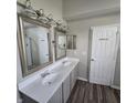Bathroom featuring a double sink vanity, a framed mirror and a separate door to the toilet and shower at 6431 Furnas Rd, Indianapolis, IN 46221